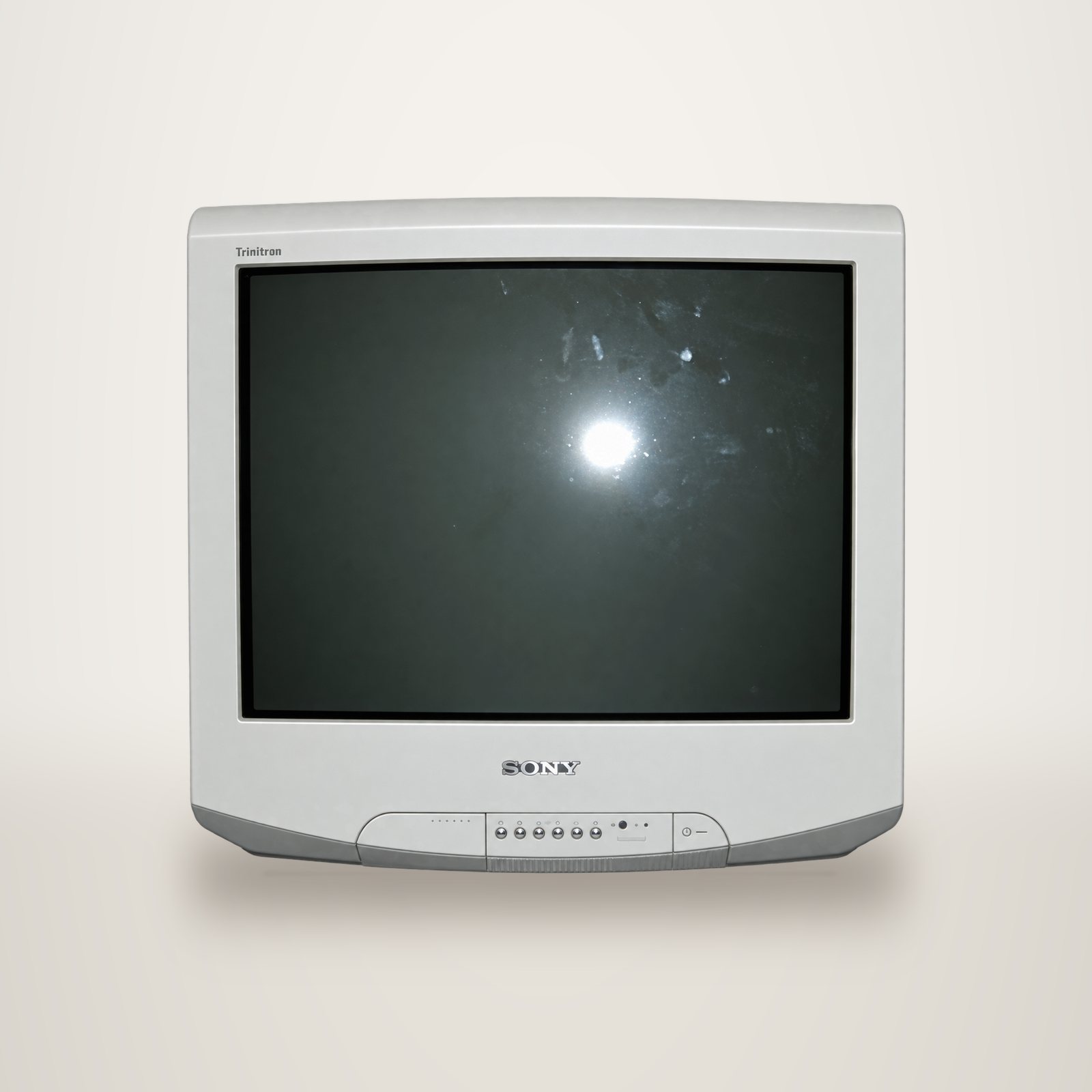Un ancien téléviseur Sony Trinitron blanc à écran cathodique plat, vu de face, avec ses boutons de commande sous l'écran.